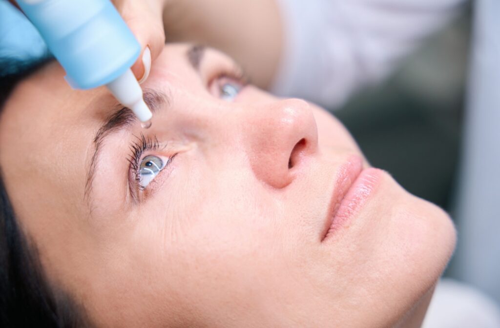 An experienced optometrist prepares dilating eye drops for a patient.