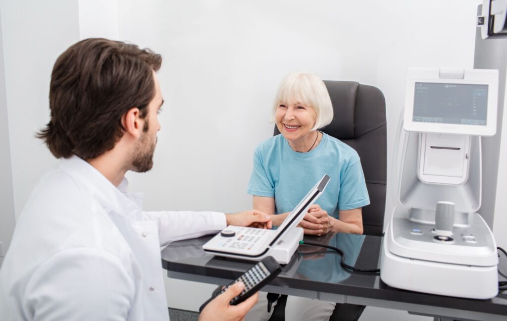 A senior smiles at their optometrist as they go over the results of the senior's annual eye exam.