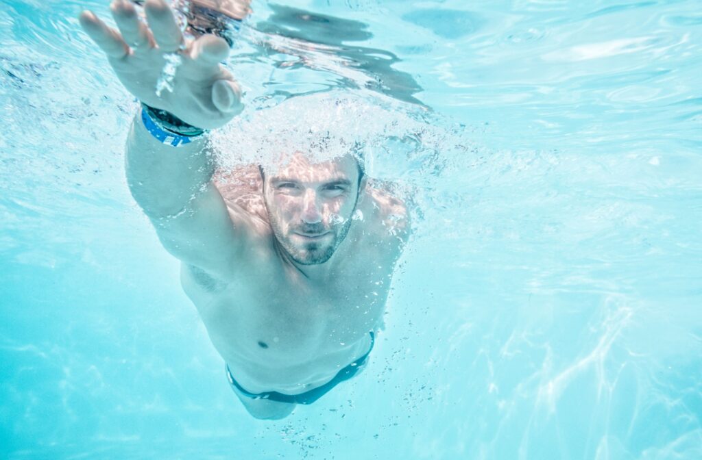 A person swimming with their eyes open under water.