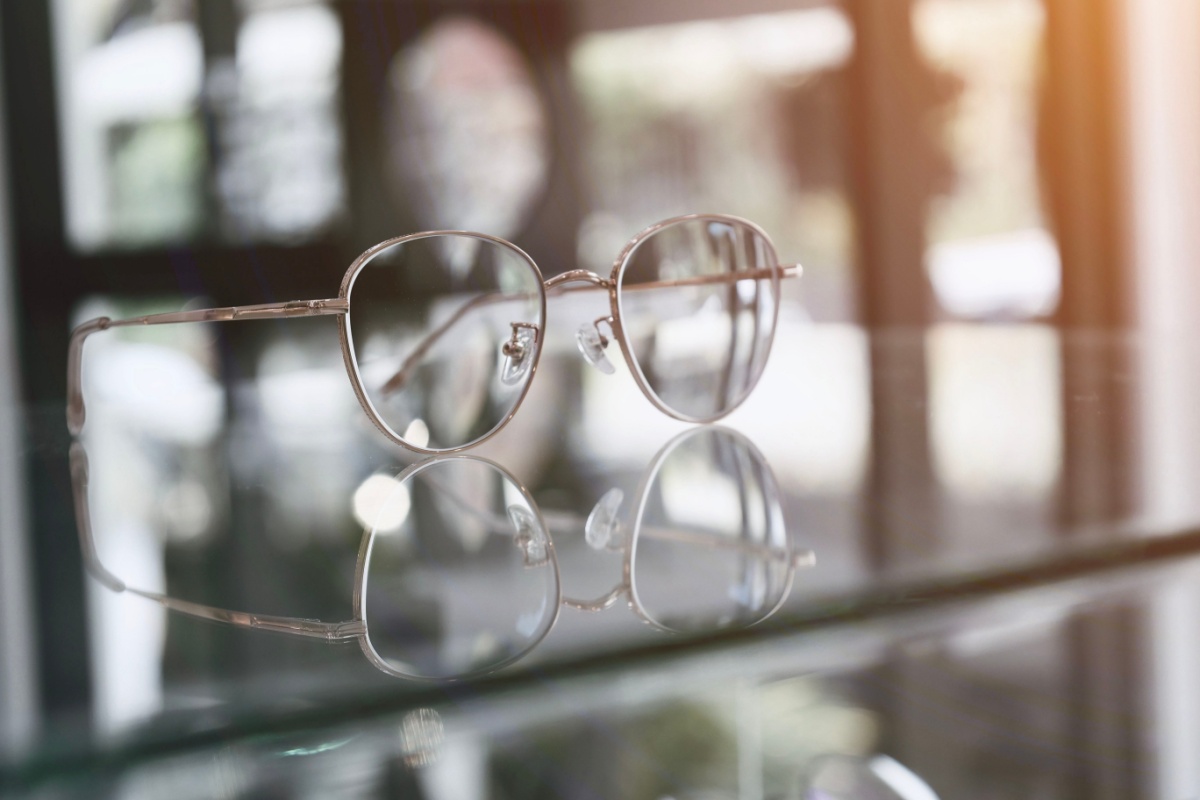 A pair of glasses with lens coatings sitting on a table.